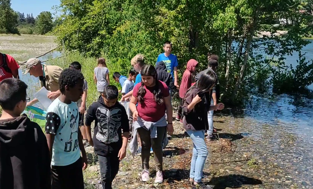Group of students along bank of the American River participating in a River Bend Science Center class.